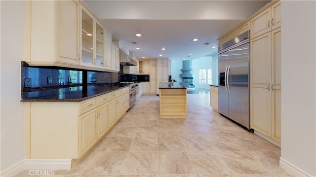22500 N Summit Ridge Cir, Chatsworth, CA 91311 - kitchen with high quality appliances, cream cabinetry, wall chimney range hood, glass insert cabinets, and recessed lighting