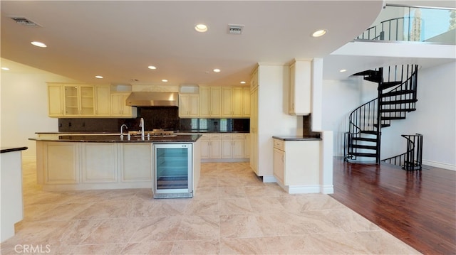 22500 N Summit Ridge Cir, Chatsworth, CA 91311 - kitchen featuring wine cooler, wall chimney range hood, dark countertops, cream cabinets, and recessed lighting