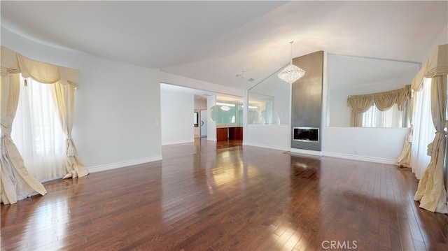 22500 N Summit Ridge Cir, Chatsworth, CA 91311 - unfurnished living room featuring wood-type flooring, vaulted ceiling, a chandelier, and a glass covered fireplace