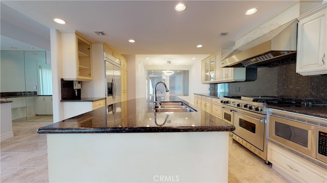 22500 N Summit Ridge Cir, Chatsworth, CA 91311 - kitchen with built in appliances, a kitchen island with sink, recessed lighting, wall chimney exhaust hood, and glass insert cabinets