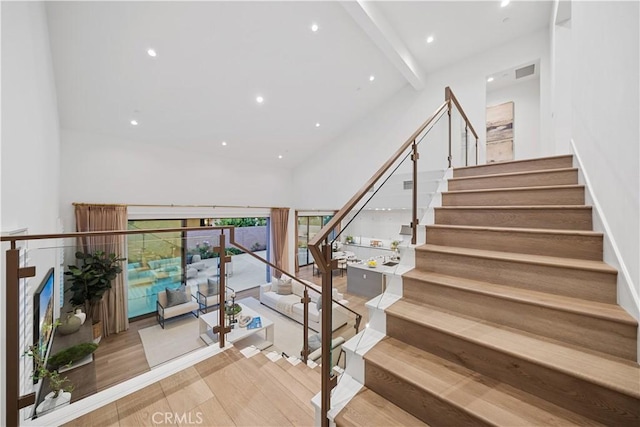 101 Lustro, Irvine, CA 92602 - stairs featuring high vaulted ceiling, wood finished floors, beamed ceiling, and recessed lighting