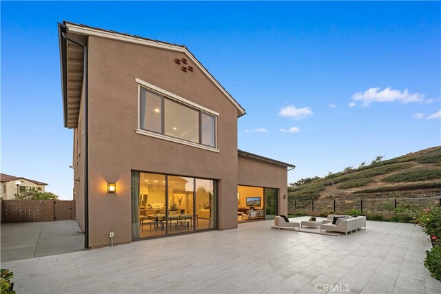 101 Lustro, Irvine, CA 92602 - back of property featuring a patio, an outdoor hangout area, and stucco siding