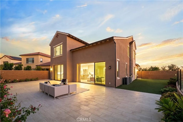 101 Lustro, Irvine, CA 92602 - back of house at dusk featuring a patio, a fenced backyard, stucco siding, an outdoor living space, and a tile roof
