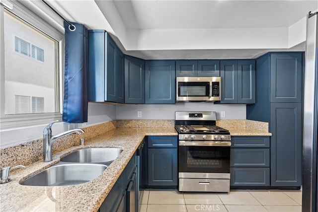 10155 De Soto Ave Unit 104, Chatsworth, CA 91311 - kitchen with appliances with stainless steel finishes, light tile patterned floors, blue cabinetry, and light stone counters