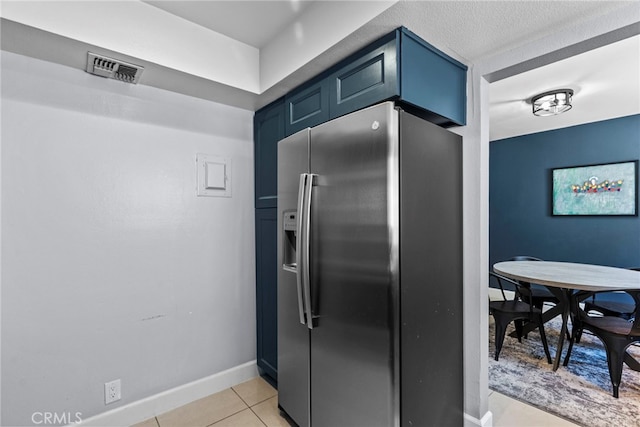 10155 De Soto Ave Unit 104, Chatsworth, CA 91311 - kitchen with stainless steel fridge with ice dispenser, blue cabinets, and light tile patterned floors