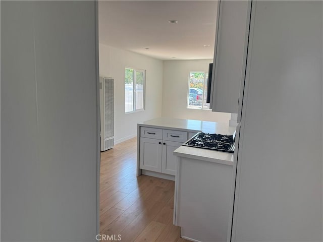 315 S Walnut Ave, Placentia, CA 92870 - kitchen featuring a heating unit, light wood finished floors, gas cooktop, light countertops, and white cabinetry