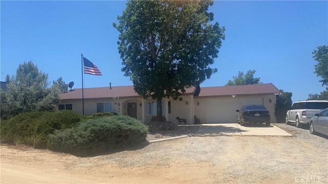 8978 Broken Spur Rd, Pinon Hills, CA 92372 - single story home with driveway, an attached garage, and stucco siding