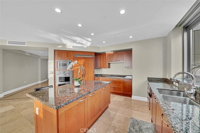 5124 Scholarship Unit 1007, Irvine, CA 92612 - kitchen featuring built in appliances, recessed lighting, dark stone counters, a kitchen island, and brown cabinets