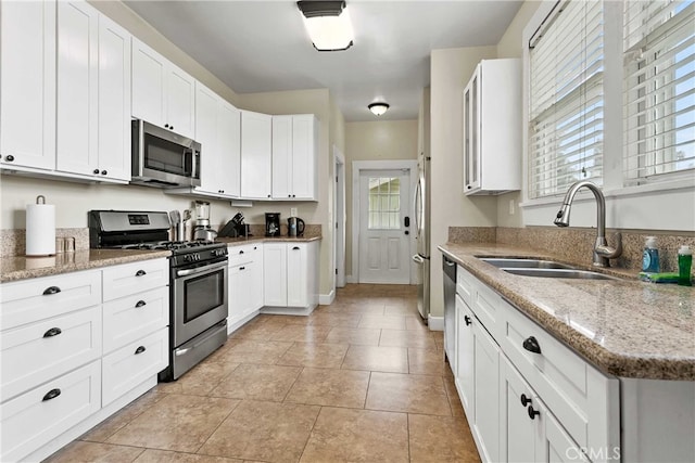 3354 Orange St, Riverside, CA 92501 - kitchen with stainless steel appliances, plenty of natural light, white cabinets, and light stone counters