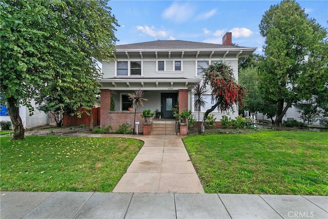 3354 Orange St, Riverside, CA 92501 - view of front of house with a porch, a front lawn, a chimney, and brick siding