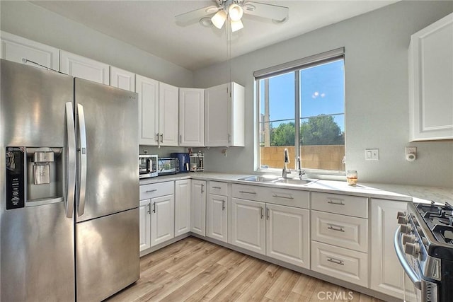 25401 Holly Beach Dr, Saugus, CA 91350 - kitchen with stainless steel appliances, light countertops, white cabinetry, and a ceiling fan