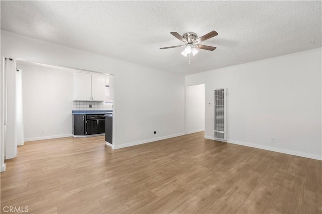 1410 Gulf Ave, Wilmington, CA 90744 - unfurnished living room with ceiling fan, a heating unit, light wood-style floors, and a textured ceiling