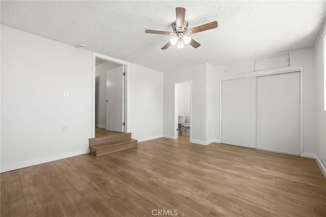 1410 Gulf Ave, Wilmington, CA 90744 - unfurnished bedroom featuring a textured ceiling, wood finished floors, a closet, ceiling fan, and connected bathroom