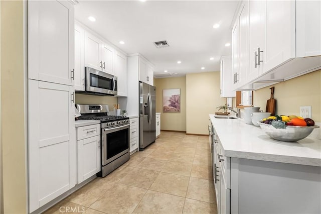 7021 Shoshone Ave, Lake Balboa, CA 91406 - kitchen with stainless steel appliances, recessed lighting, light countertops, light tile patterned floors, and white cabinetry