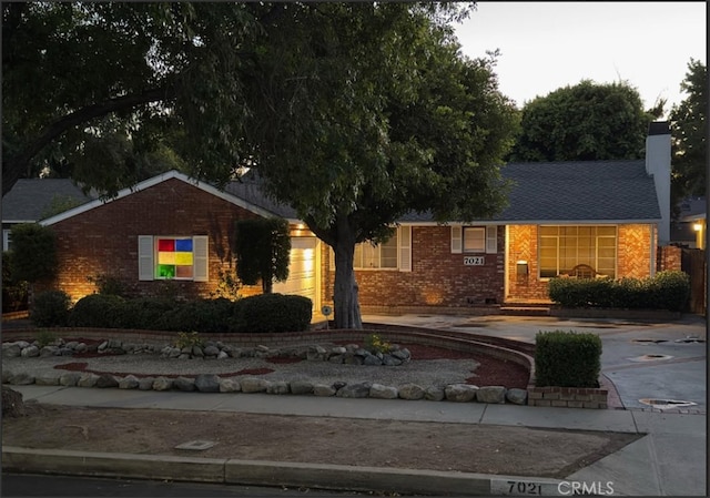 7021 Shoshone Ave, Lake Balboa, CA 91406 - ranch-style house with brick siding, concrete driveway, and a chimney