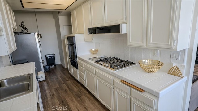 5310 Zelzah Ave Unit 312, Encino, CA 91316 - kitchen featuring stainless steel appliances, dark wood finished floors, backsplash, and tile counters