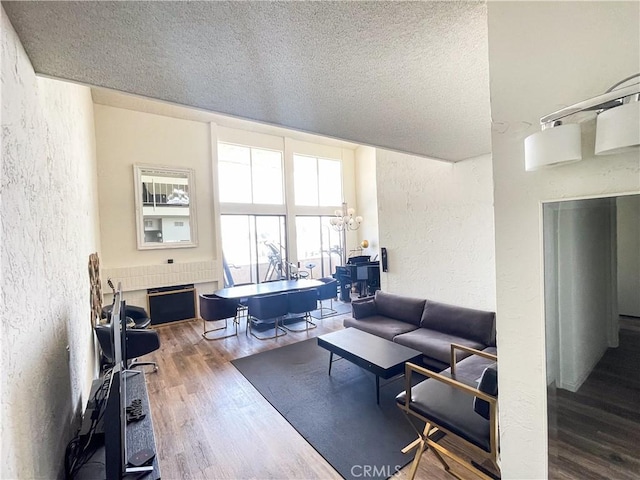5310 Zelzah Ave Unit 312, Encino, CA 91316 - living area with a textured wall, a textured ceiling, wood finished floors, a fireplace, and a chandelier