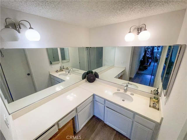 5310 Zelzah Ave Unit 312, Encino, CA 91316 - bathroom featuring a textured ceiling, double vanity, and wood finished floors
