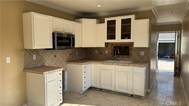 9206 Elizabeth Ave, South Gate, CA 90280 - kitchen with stainless steel microwave, tile countertops, glass insert cabinets, white cabinets, and recessed lighting