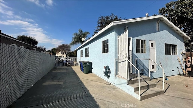 9206 Elizabeth Ave, South Gate, CA 90280 - view of home's exterior featuring stucco siding, a patio area, and a gate