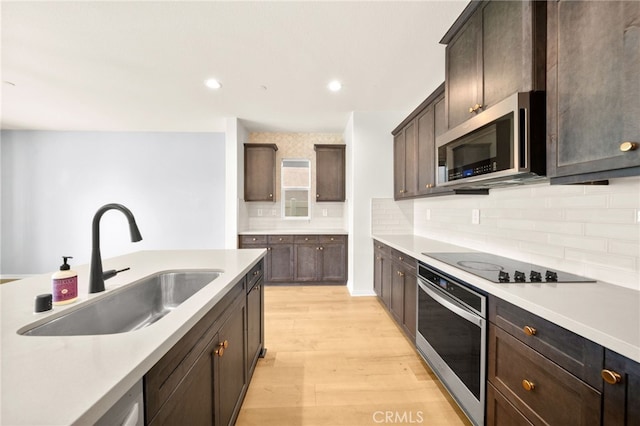 28426 Joey Ct, Menifee, CA 92585 - kitchen with stainless steel appliances, light wood-style floors, tasteful backsplash, light countertops, and dark brown cabinets