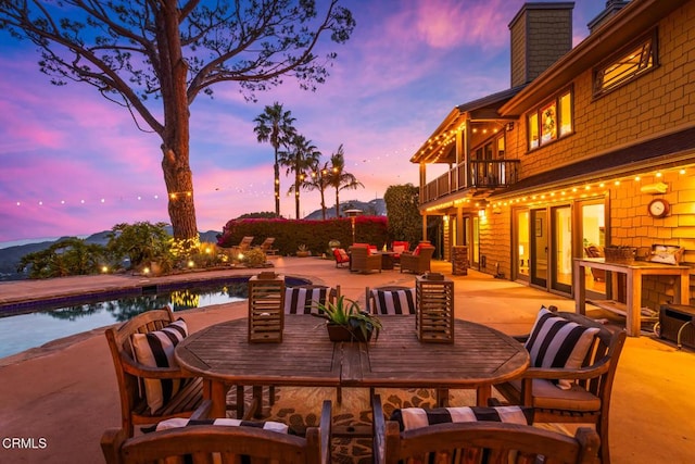 3626 Saint Elizabeth Rd, Glendale, CA 91206 - patio terrace at dusk with a balcony, an outdoor living space, a patio area, outdoor dining space, and an outdoor pool