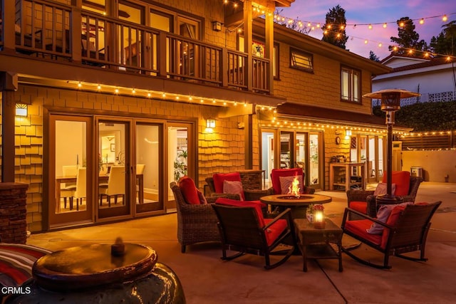 3626 Saint Elizabeth Rd, Glendale, CA 91206 - back of property at dusk featuring a balcony, a fire pit, and a patio area