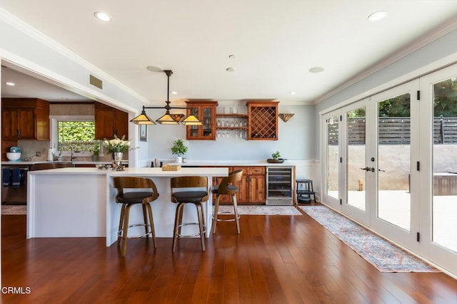 3626 Saint Elizabeth Rd, Glendale, CA 91206 - kitchen featuring wine cooler, brown cabinetry, light countertops, crown molding, and hanging light fixtures