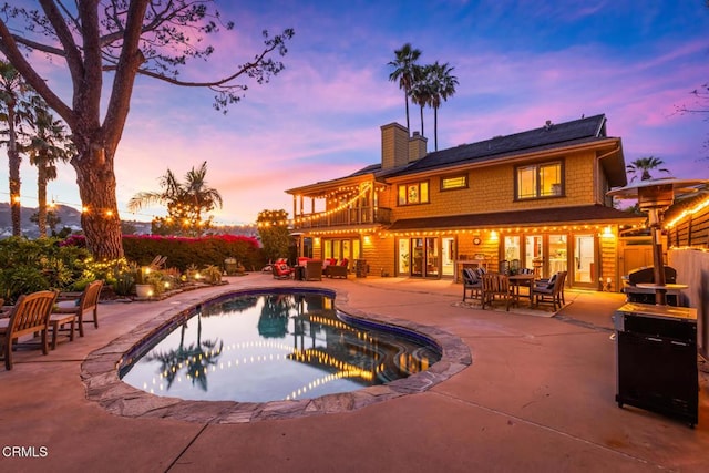 3626 Saint Elizabeth Rd, Glendale, CA 91206 - pool at dusk featuring a patio, an outdoor pool, and an outdoor living space