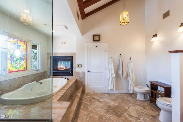 3626 Saint Elizabeth Rd, Glendale, CA 91206 - bathroom with a bidet, high vaulted ceiling, a jetted tub, a tiled fireplace, and beamed ceiling
