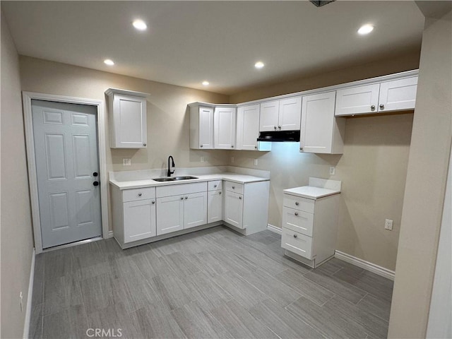 2311 5th St, Riverside, CA 92507 - kitchen featuring under cabinet range hood, recessed lighting, white cabinets, light wood-type flooring, and light countertops