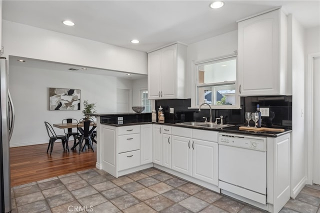 6515 Amigo Ave, Reseda, CA 91335 - kitchen featuring dishwasher, dark countertops, backsplash, white cabinets, and a peninsula