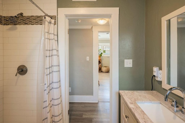 1396 N Ferger Ave, Fresno, CA 93728 - bathroom with a tile shower, wood finished floors, vanity, and ornamental molding