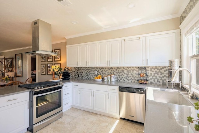 1396 N Ferger Ave, Fresno, CA 93728 - kitchen with appliances with stainless steel finishes, island range hood, decorative backsplash, ornamental molding, and white cabinets