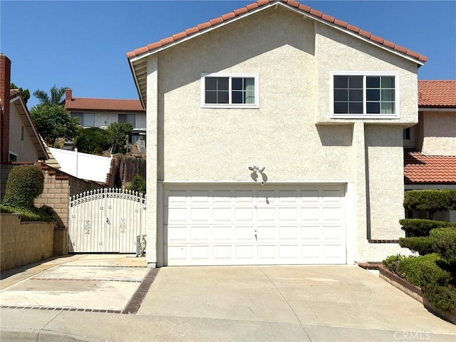 2227 Langspur Dr, Hacienda Heights, CA 91745 - view of home's exterior with an attached garage, stucco siding, concrete driveway, a tiled roof, and a gate