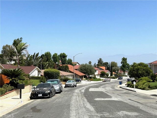 2227 Langspur Dr, Hacienda Heights, CA 91745 - view of asphalt street with sidewalks, curbs, a residential view, and street lighting