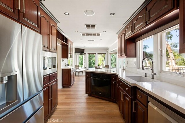 18310 Canon St, Devore, CA 92407 - kitchen featuring black appliances, light wood-style flooring, light countertops, a peninsula, and recessed lighting