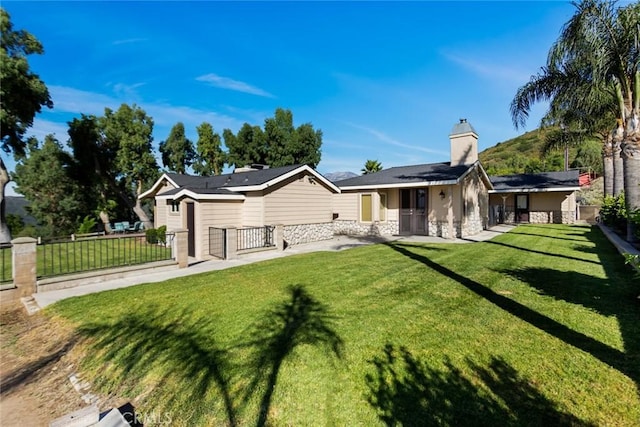 18310 Canon St, Devore, CA 92407 - rear view of house with stone siding, a chimney, and a gate