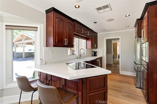 18310 Canon St, Devore, CA 92407 - kitchen with a peninsula, black electric stovetop, freestanding refrigerator, light countertops, and crown molding