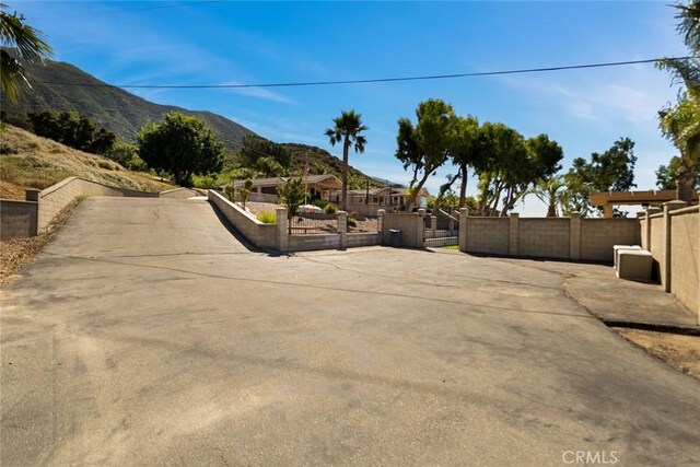18310 Canon St, Devore, CA 92407 - view of concrete driveway featuring a mountain view and a gate
