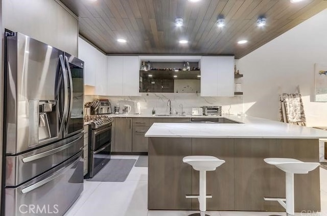 2727 Pine Creek Cir, Fullerton, CA 92835 - kitchen featuring appliances with stainless steel finishes, open shelves, recessed lighting, a kitchen bar, and backsplash
