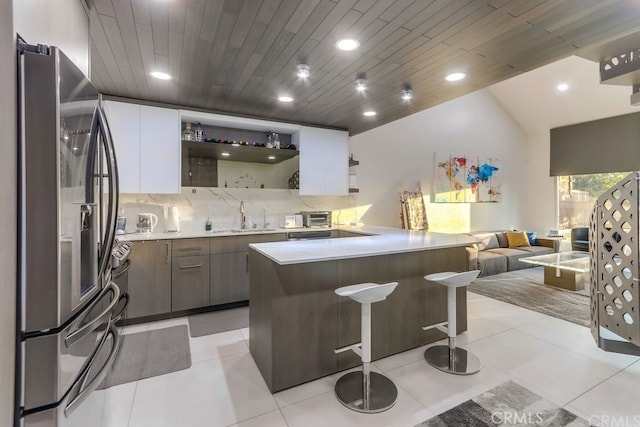 2727 Pine Creek Cir, Fullerton, CA 92835 - kitchen featuring freestanding refrigerator, open shelves, open floor plan, decorative backsplash, and a kitchen bar