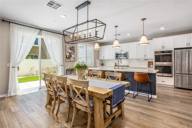 849 Half Moon Ave, Redlands, CA 92374 - dining room with light wood finished floors, recessed lighting, and a chandelier