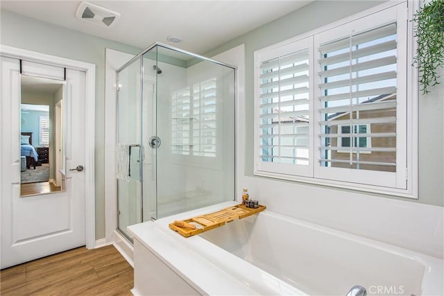 849 Half Moon Ave, Redlands, CA 92374 - ensuite bathroom featuring a bath, a stall shower, and wood finished floors