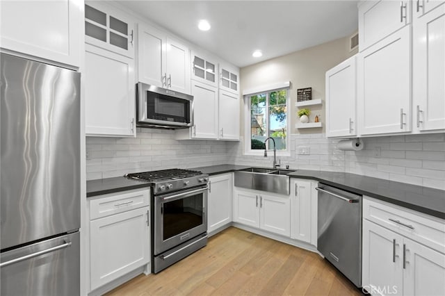 22 Brassie Ln, Coto De Caza, CA 92679 - kitchen with appliances with stainless steel finishes, dark countertops, open shelves, white cabinets, and light wood finished floors