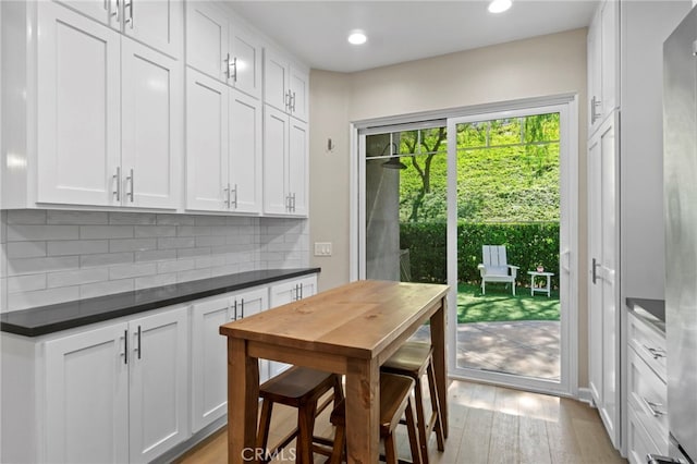 22 Brassie Ln, Coto De Caza, CA 92679 - kitchen with tasteful backsplash, dark countertops, light wood-type flooring, white cabinetry, and recessed lighting