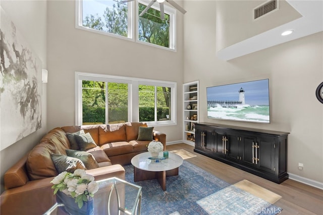 22 Brassie Ln, Coto De Caza, CA 92679 - living room featuring a high ceiling, wood finished floors, healthy amount of natural light, built in features, and ceiling fan