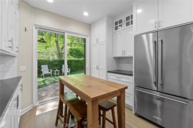 22 Brassie Ln, Coto De Caza, CA 92679 - kitchen with high end refrigerator, dark countertops, white cabinetry, light wood finished floors, and recessed lighting