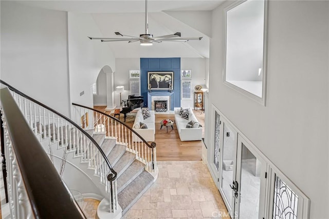 25291 Derbyhill Dr, Laguna Hills, CA 92653 - foyer entrance featuring high vaulted ceiling, ceiling fan, a large fireplace, arched walkways, and stairway