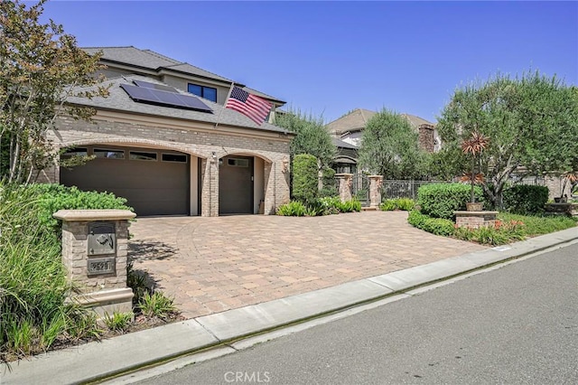 25291 Derbyhill Dr, Laguna Hills, CA 92653 - view of front facade with roof mounted solar panels, brick siding, decorative driveway, and an attached garage